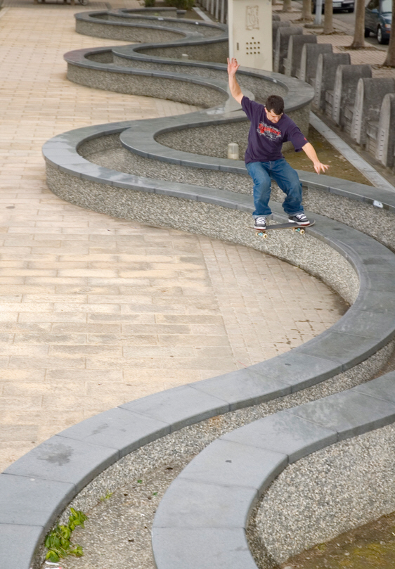 Vaughan skating along a curved ledge in a public plaza
