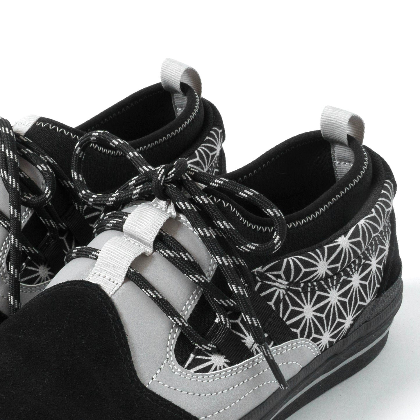 Black and white patterned sneakers with white laces on a white background