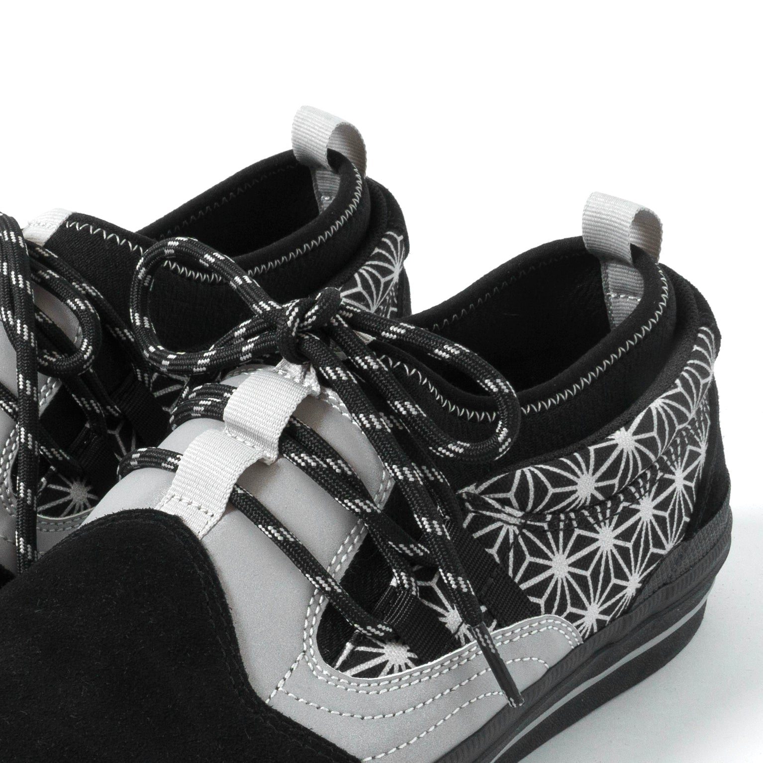 Black and white patterned sneakers with white laces on a white background