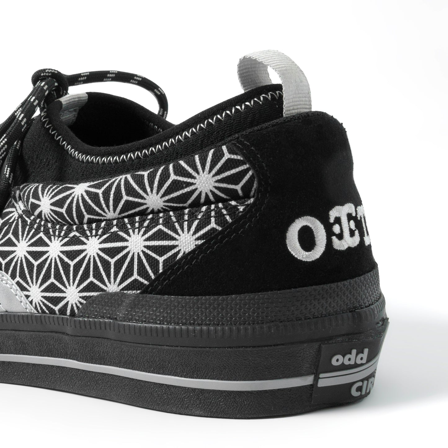 Black sneaker with white geometric pattern and 'odd' branding on a white background