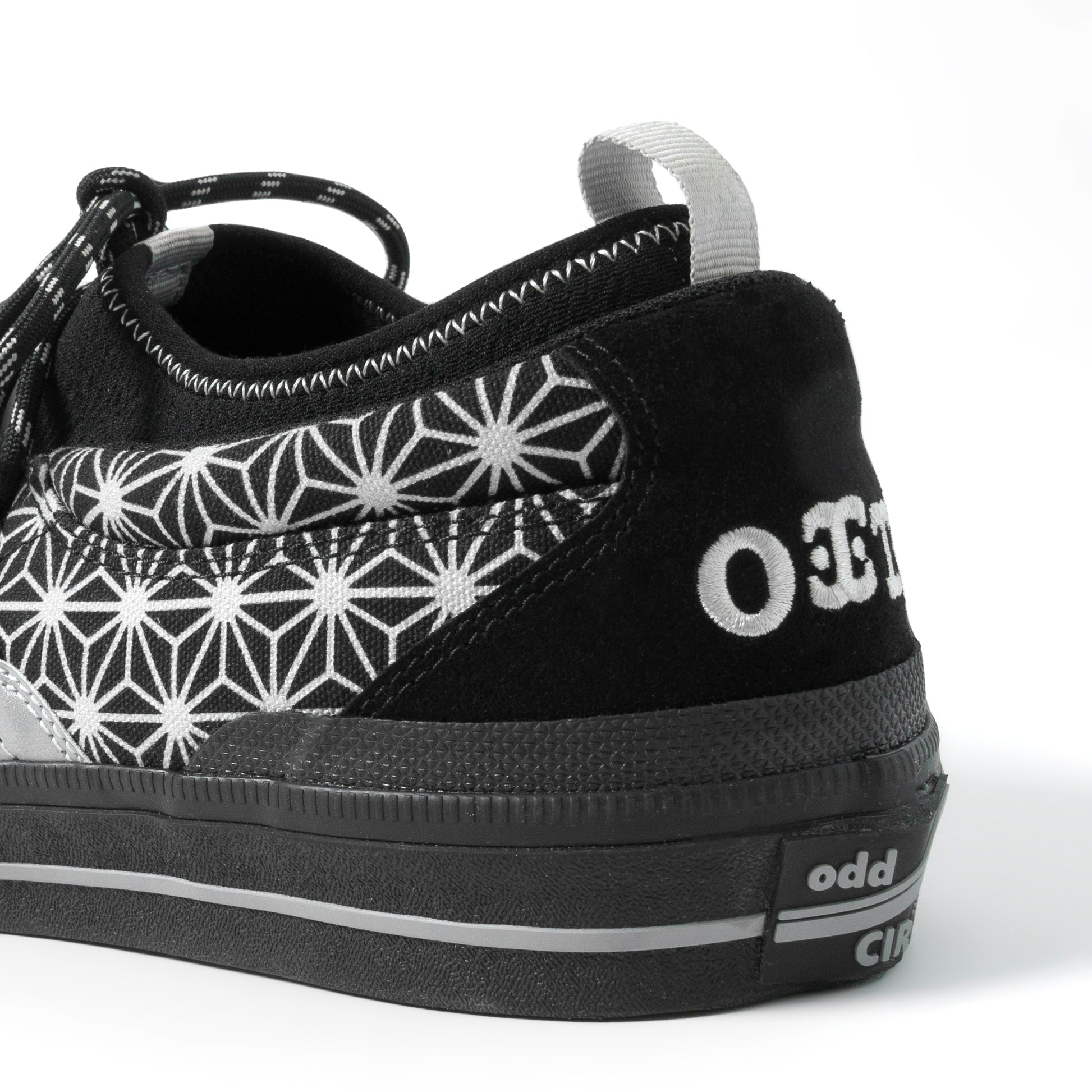 Black sneaker with white geometric pattern and 'odd' branding on a white background
