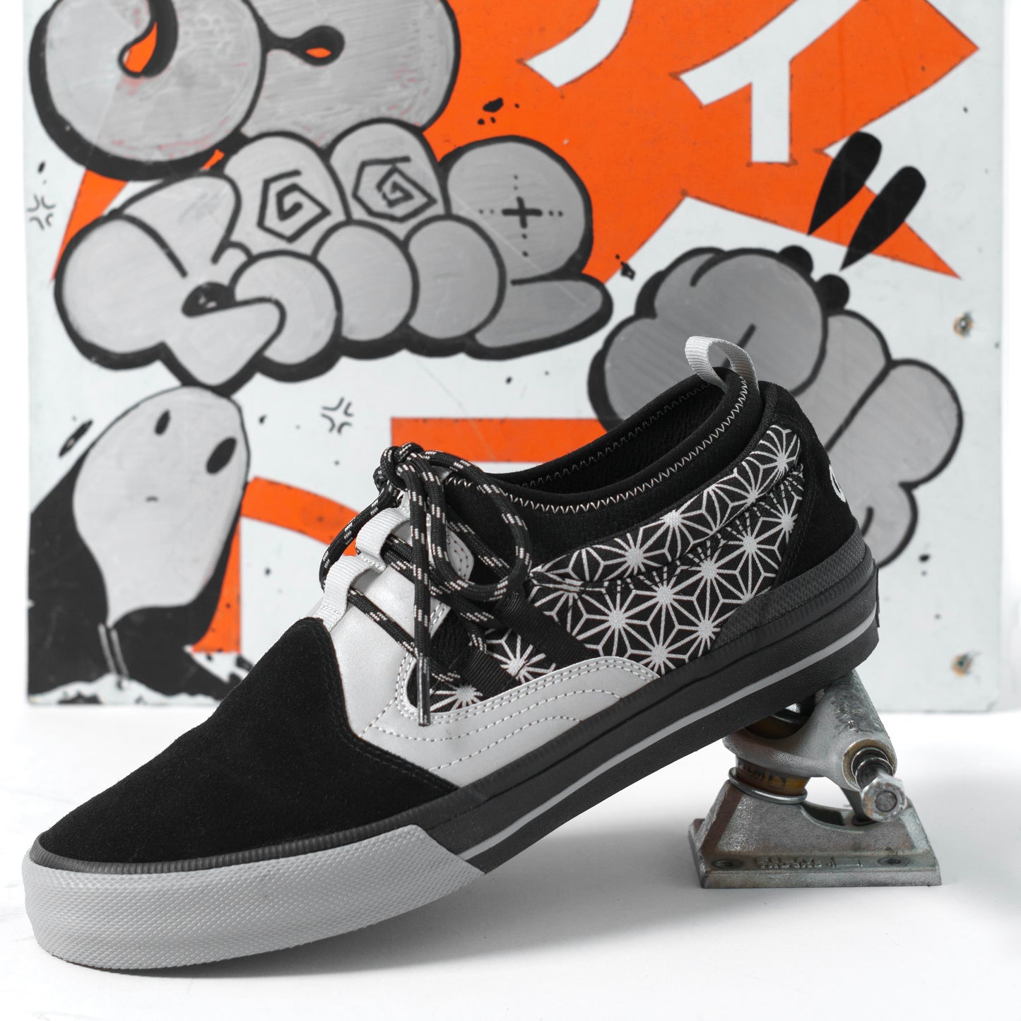 Black and white sneaker with star pattern on a graffiti-style background